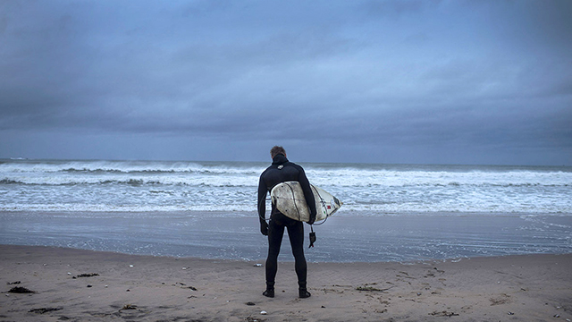 PORTRUSH, NORTHERN IRELAND - DECEMBER 6: Pro surfer Alastair Mennie watches the sea as he prepares to surf Storm Desmond on December 6, 2015 in Portrush, Northern Ireland. Storm Desmond has brought major disruption to the United Kingdom with thousands of homes left without power and severe flooding across many areas. (Photo by Charles McQuillan/Getty Images)