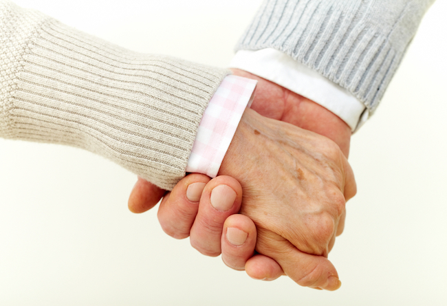 elderly people holding hands