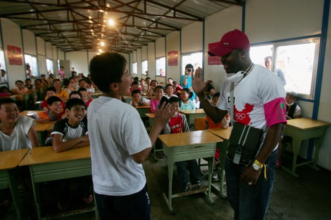 MIANZHU, SICHUAN - MAY 21: A volunteer from Nigeria teaches English in the temporary classroom at a relief center on May 21, 2008 in Deyang of Sichuan Province, China. China fight against time to deliver relief supplies to survivors amidst concerns of possible disease outbreaks. More than 40,000 people have been confirmed killed and about five million people were made homeless by the May 12 earthquake measuring 8.0 on the Richter scale, the worst in 58 years to hit China. (Photo by Feng Li/Getty Images)